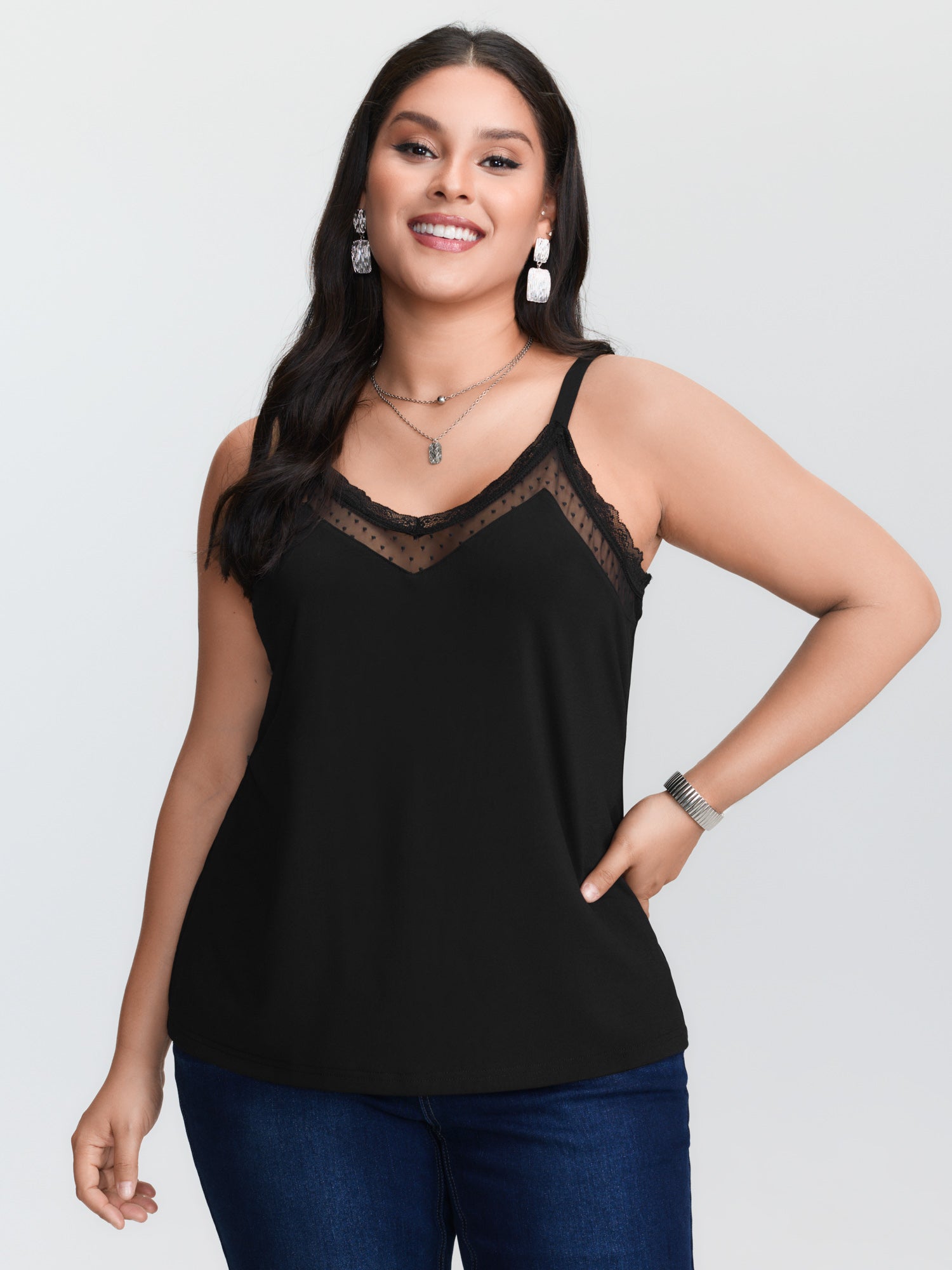 Cami Top Lace - プラスサイズ対応の黒いニットキャミソール。コントラストカラーのメッシュ素材を使用したVネックデザインで、細いスパゲッティストラップが付いています。通常丈。
